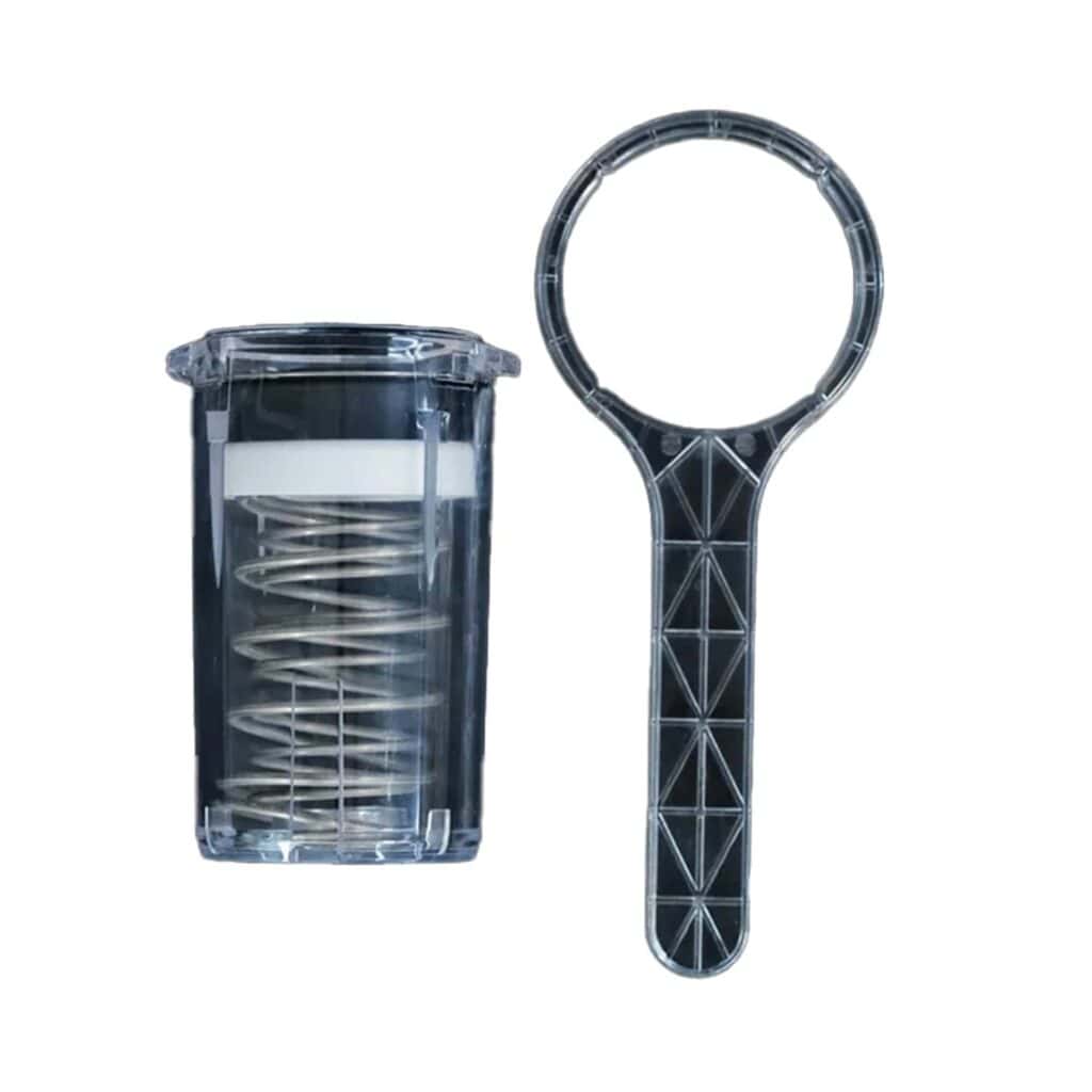 כלי שטיפה אחורית מסוג "Mischief Backflush Tool E61" בעל צורה גלילית ושקופה, שבו ניתן לראות את הקפיץ שבפנים, ניצב לצד הידית השטוחה והעגולה שלו על רקע לבן — כלים ייעודיים הקשורים לעתים קרובות למכונות קפה ולהכנת קפה איכותי. | אספרסימו