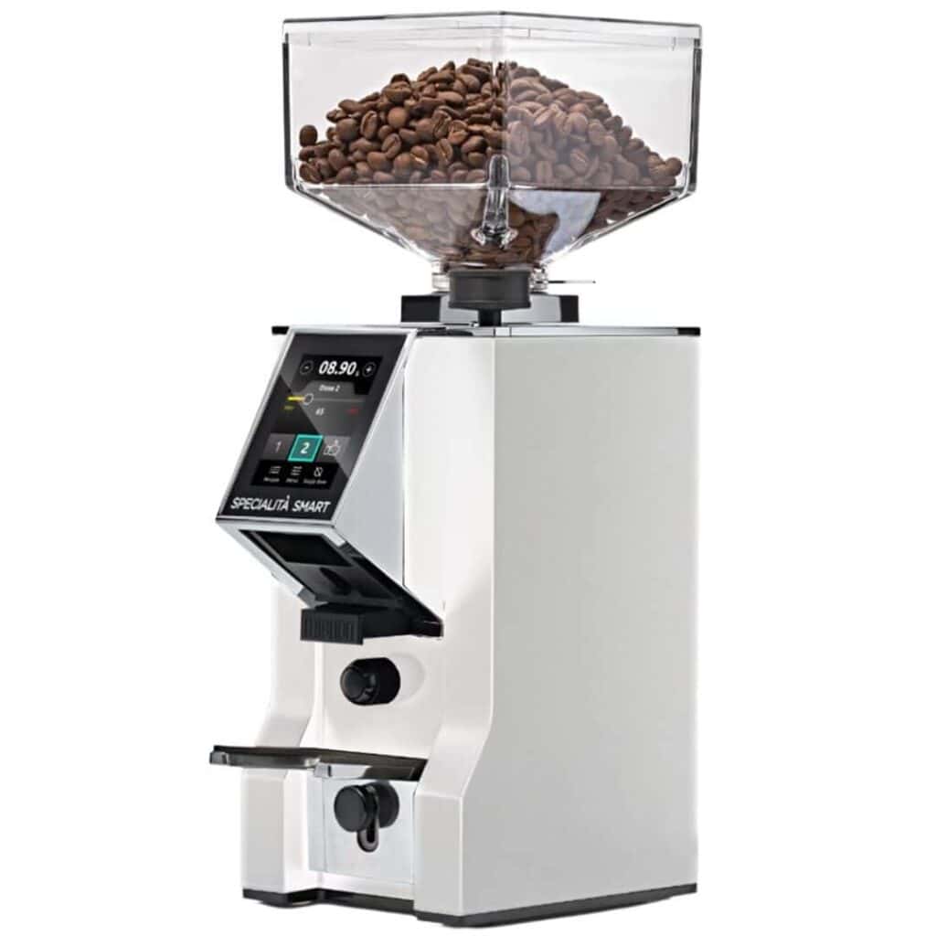 מטחנת הקפה Eureka Mignon Specialita Smart – לבן היא מטחנת קפה לבנה ומסוגננת, הכוללת מיכל שקוף למילוי פולי קפה, מסך תצוגה דיגיטלי וידיות כוונון — שנועדו לסייע לכם להשיג טחינה מדויקת להכנת כוס קפה מושלמת. המטחנה מוצגת על רקע לבן חלק. | אספרסימו