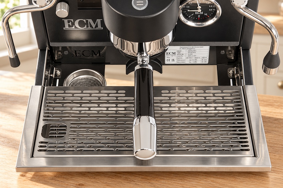 מכונת אספרסו ECM Technika V Profi PID עם מסנן קפה כרום המונח בתוך יחידת החליטה, מעל מגש טפטוף מנירוסטה. | אספרסימו