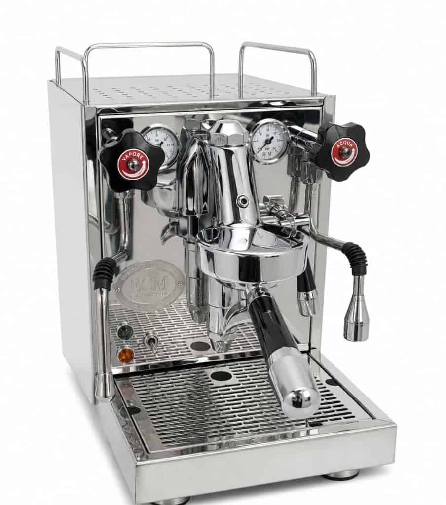 מכונת אספרסו ECM Mechanika Slim מפלדת אל-חלד מבריקה – מחודשת, הכוללת שני מדדים, ידיות בקרה בשחור ואדום, פורטפילטר וצינור אדים, המונחת על מגש טפטוף עם מסילות לכוסות בחלקו העליון — מושלמת לטחינה ולהכנת כוס קפה מושלמת. | אספרסימו