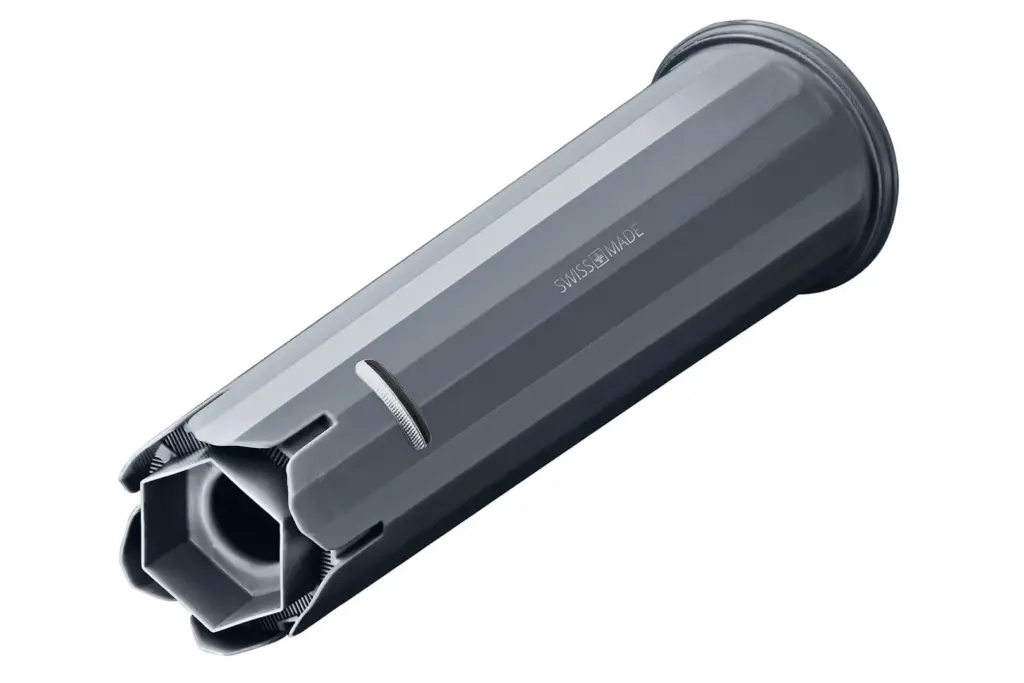 תצוגה מקרוב של מחסנית מסנן המים Jura Claris Smart, רכיב גלילי מתכתי הכולל חריצים רבים ופתח משושה בקצהו האחד. על צדו מוטבע הכיתוב “SWISS MADE”. | אספרסימו