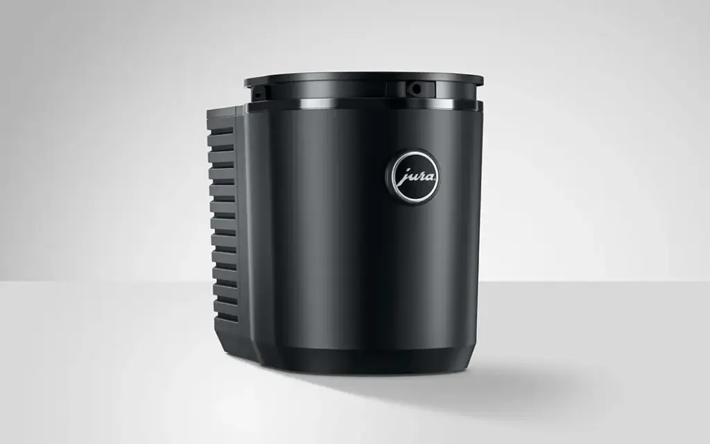 מקרר חלב גלילי שחור מדגם Cool Control בנפח 1 ליטר למכונות הקפה של JURA, עם פתח אוורור בחלק האחורי ולוגו עגול בחלק הקדמי. | אספרסימו