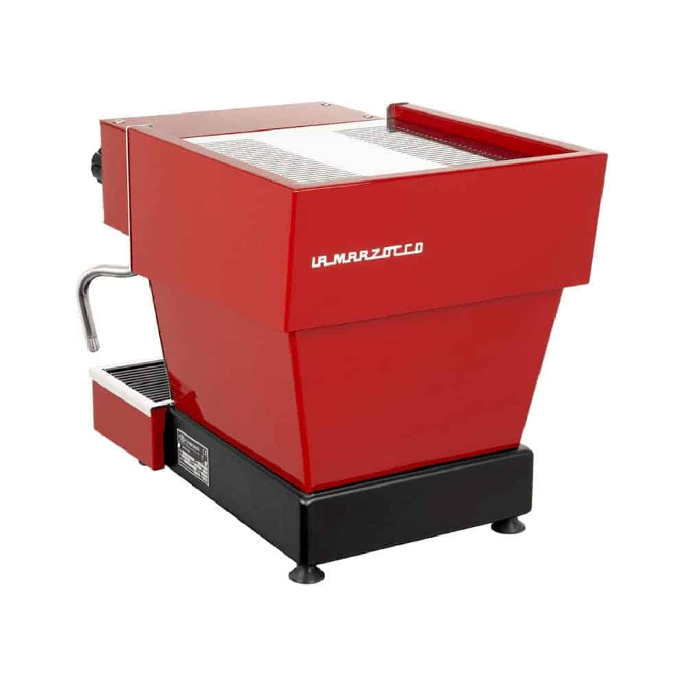מכונת אספרסו אדומה מדגם La Marzocco, הנראית מזווית אחורית, עם משטח עליון ממתכת מבריקה, זרבובית אדים בצד שמאל ובסיס שחור עם שתי רגליות קטנות מתכווננות — מושלמת ליהנות מקפה איכותי וארומה עשירה בכל כוס. | אספרסימו