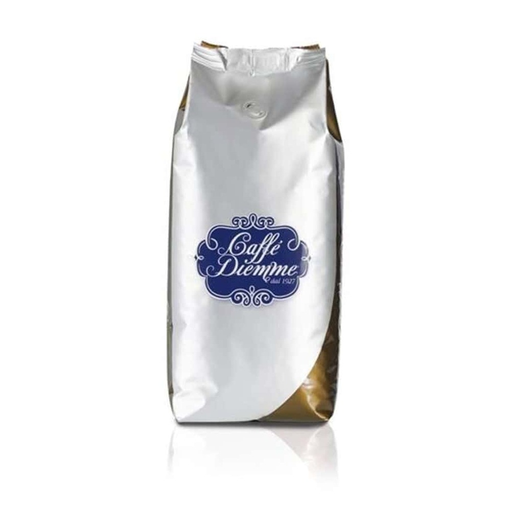 שקית עומדת בצבעי כסף וזהב מכילה פולי קפה Caffe Diemme Gold במשקל 1 ק"ג, עם תווית מעוטרת בכחול ולבן הנושאת את הלוגו של המותג "Caffe Diemme". האריזה, האטומה בחלקה העליון, מדגישה את איכות הקפה ואת הארומה העשירה. | אספרסימו