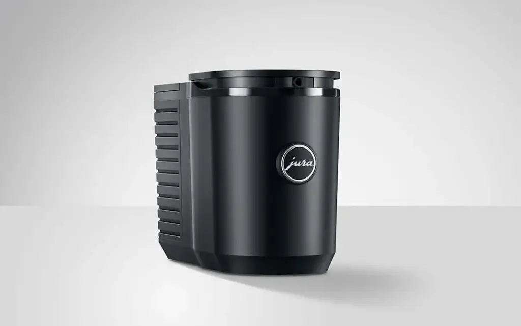 מקרר חלב Jura Cool Control שחור ומלוטש בנפח 0.6 ליטר, בעל צורה גלילית ולוגו בחזיתו, מונח על משטח אפור בהיר על רקע אחיד. | אספרסימו